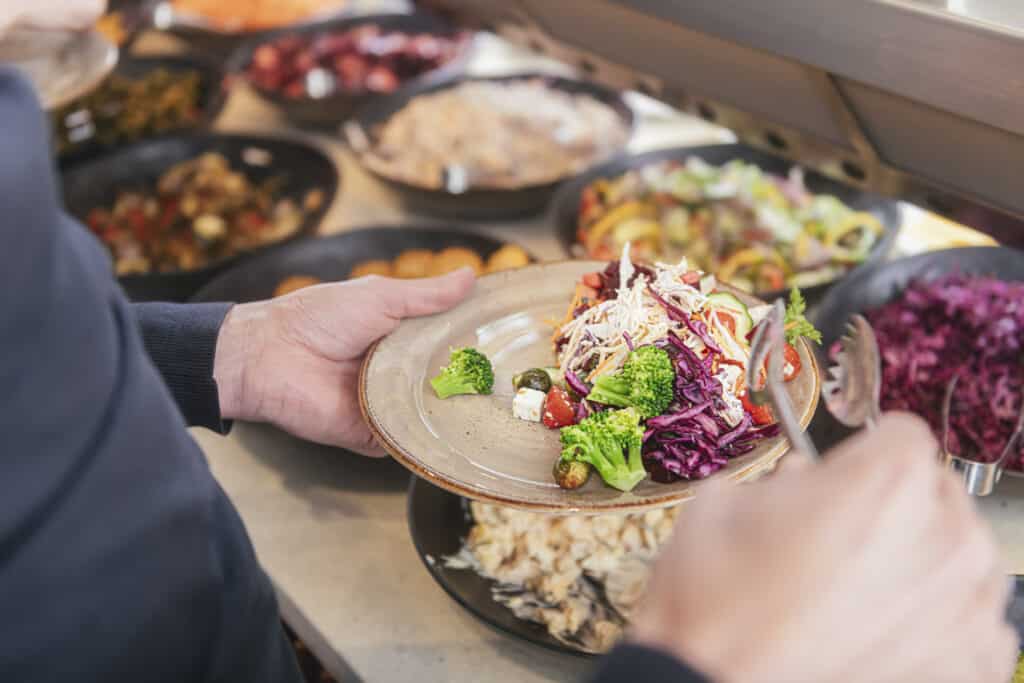 Lokaal en duurzaam lunchbuffet tijdens een zakelijk event bij De Mauritskazerne, met verse gerechten als verbindend onderdeel van het programma.